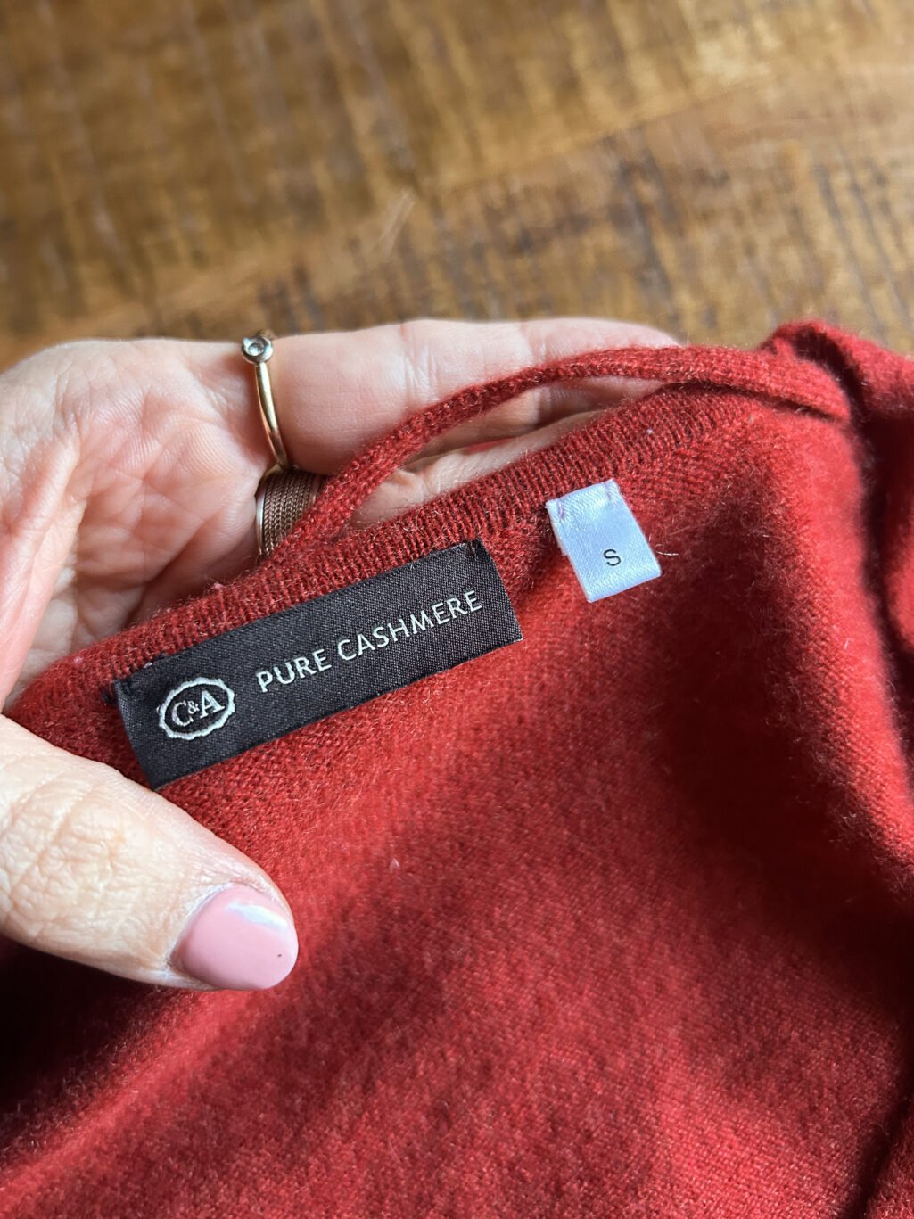 C&A Cashmere Cardigan in Orange Rot mit Kn&ouml;pfen. Preloved. Gefaltet auf Holztisch.