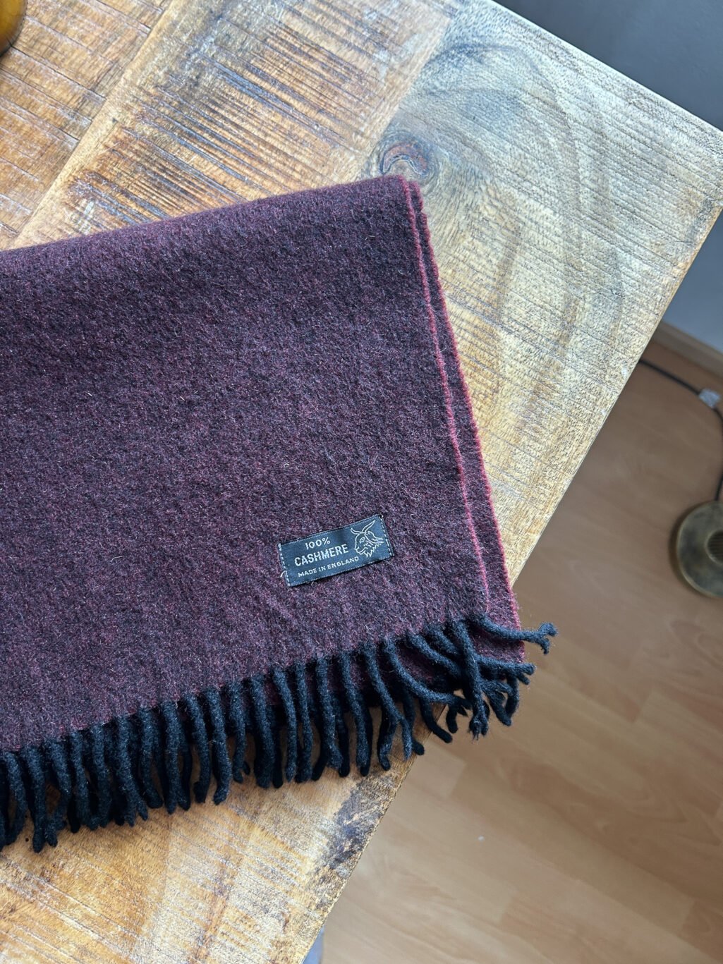 Preloved Kaschmir Schal in Burgundy, Made in England, gefaltet auf Holztisch.