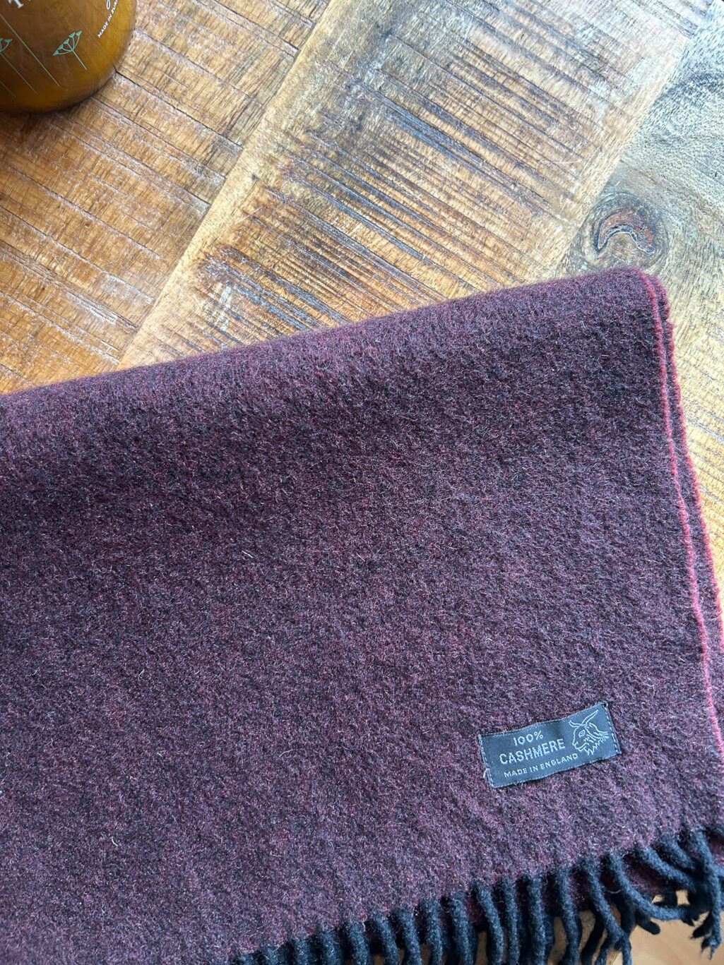 Preloved Kaschmir Schal in Burgundy, Made in England, gefaltet auf Holztisch.
