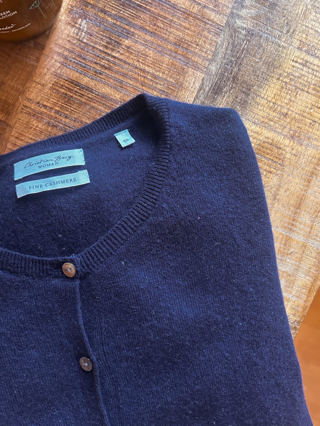 Christian Berg Cardigan aus 100% Kaschmir in Dunkelblau. Secondhand. Gefaltet auf Holztisch.