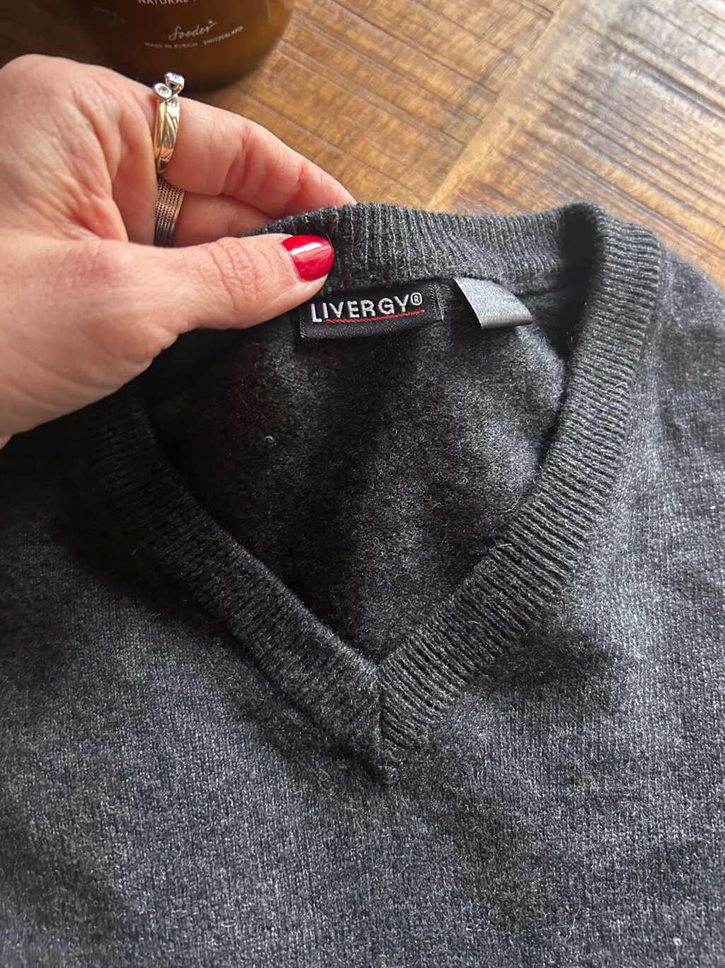 Dunkelgrauer preloved Cashmere-Pullover von Livergy mit V-Ausschnitt, gefaltet auf Holztisch, feiner Strick aus 100 % Cashmere.
