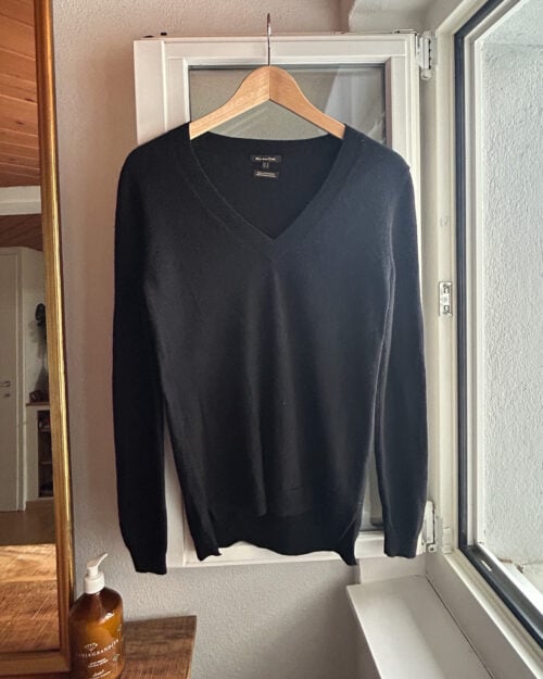 Secondhand Cashmere Pullover von Massimo Dutti in Schwarz mit V-Neck, aufgeh&auml;ngt an Kleiderb&uuml;gel.