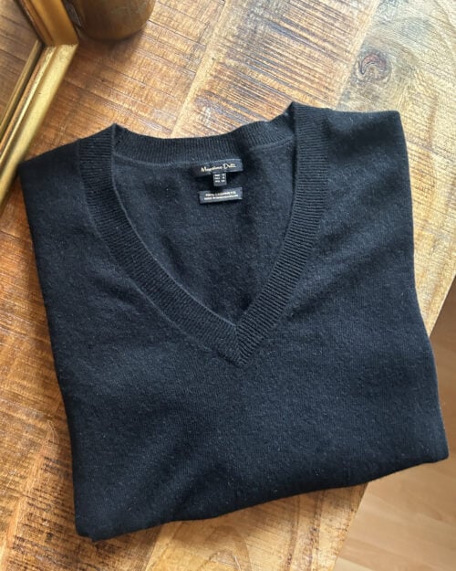 Secondhand Cashmere Pullover von Massimo Dutti in Schwarz mit V-Neck, gefaltet auf Holztisch.
