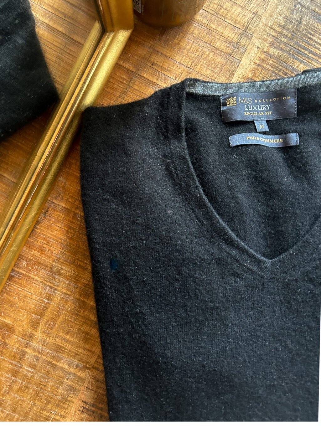 Schwarzer preloved Regular Fit Kaschmir Pullover mit V-Neck f&uuml;r Herren. Gefaltet auf Holztisch.