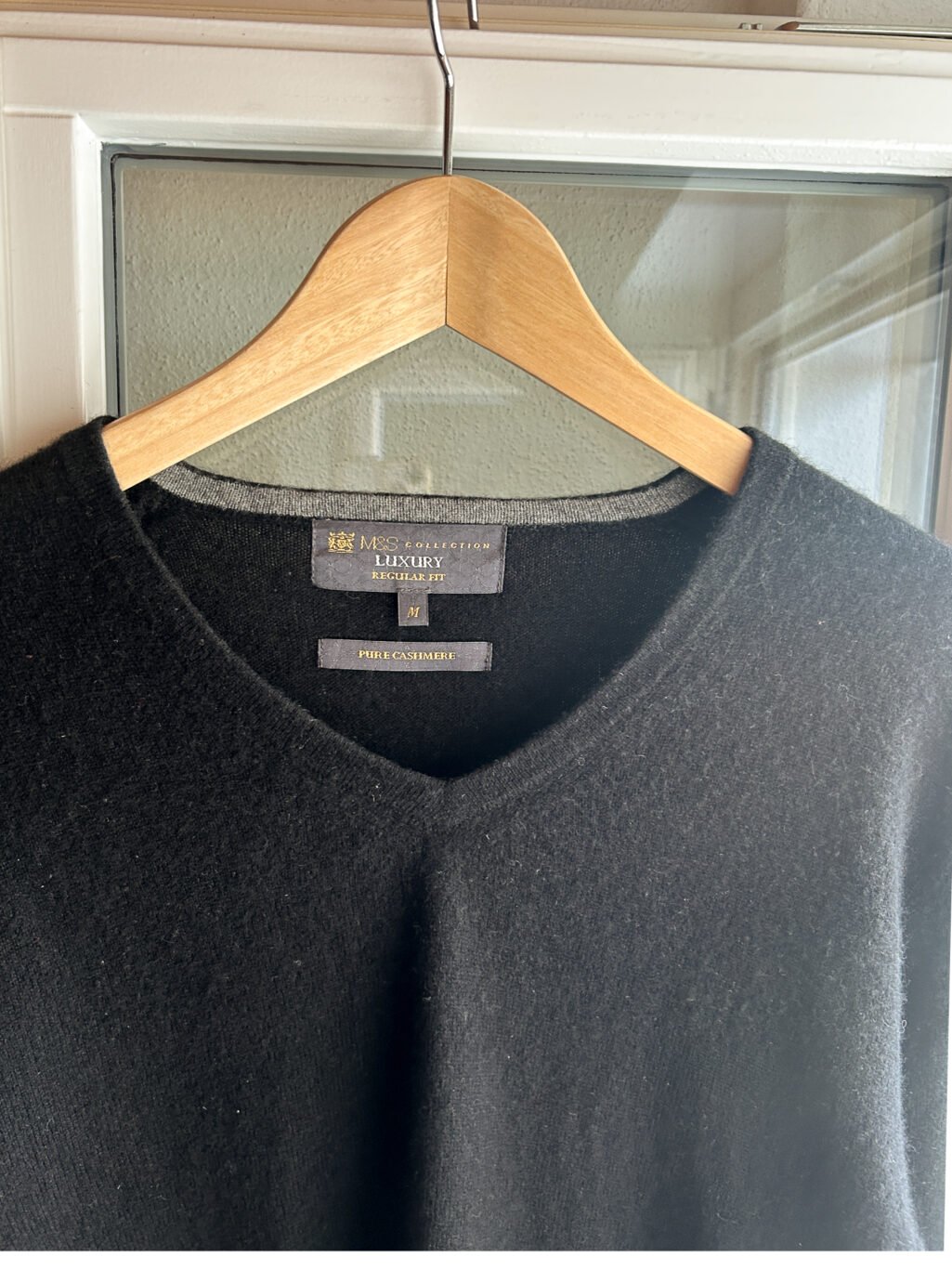Schwarzer preloved Regular Fit Kaschmir Pullover mit V-Neck f&uuml;r Herren. H&auml;ngend an Kleiderb&uuml;gel.