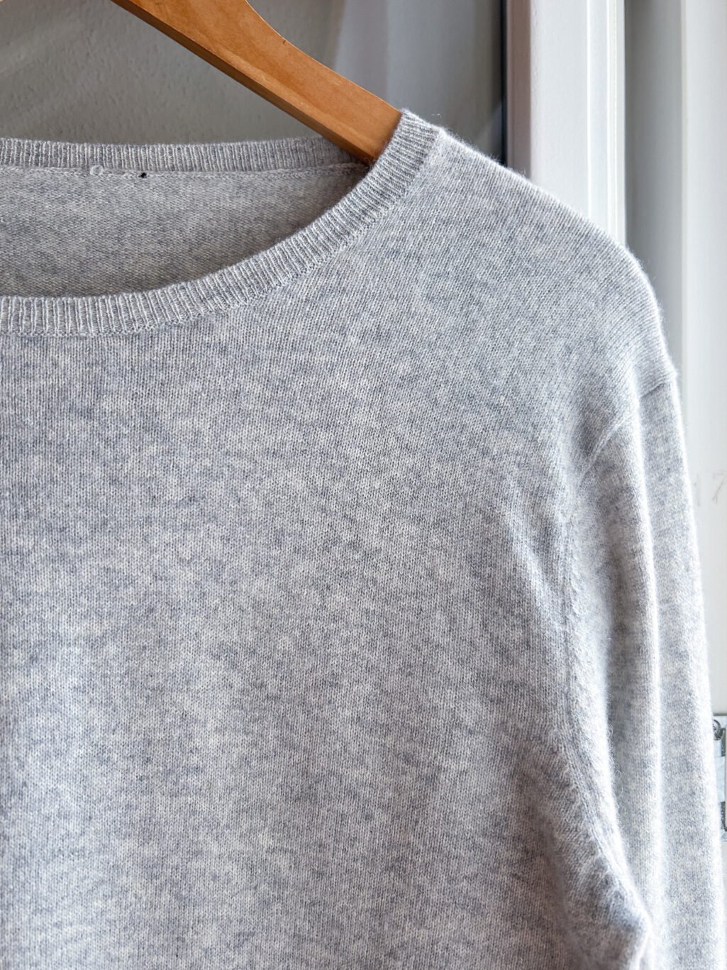 Tex Secondhand Cashmere Pullover in Grau, augeh&auml;ngt an Kleiderb&uuml;gel.