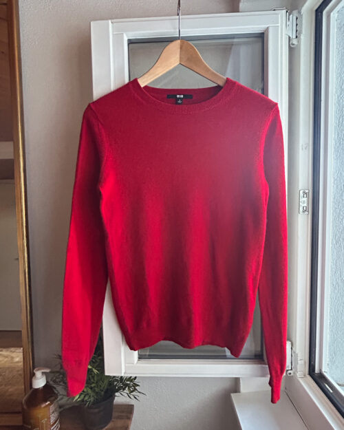 Secondhand Kaschmirpullover von Uniqlo in Rot. An Kleiderb&uuml;gel aufgeh&auml;ngt.