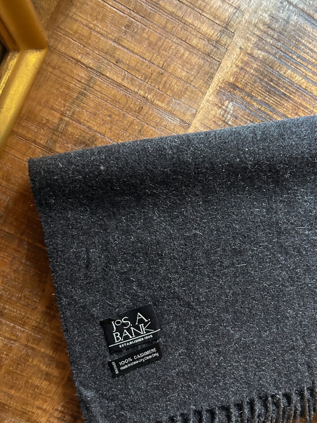 Grauer preloved Jos. A. Bank Schal aus 100% Kaschmir. Gefaltet auf Holztisch.