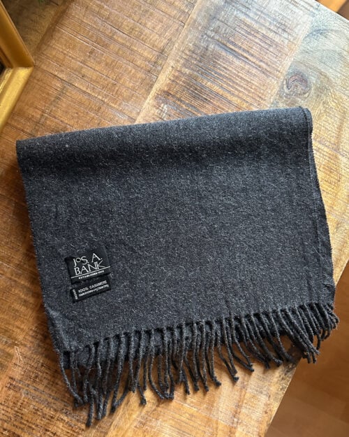 JOS A BANK CASHMERE SCHAL GRAU PRELOVED-5 Grauer preloved Jos. A. Bank Schal aus 100% Kaschmir. Gefaltet auf Holztisch.