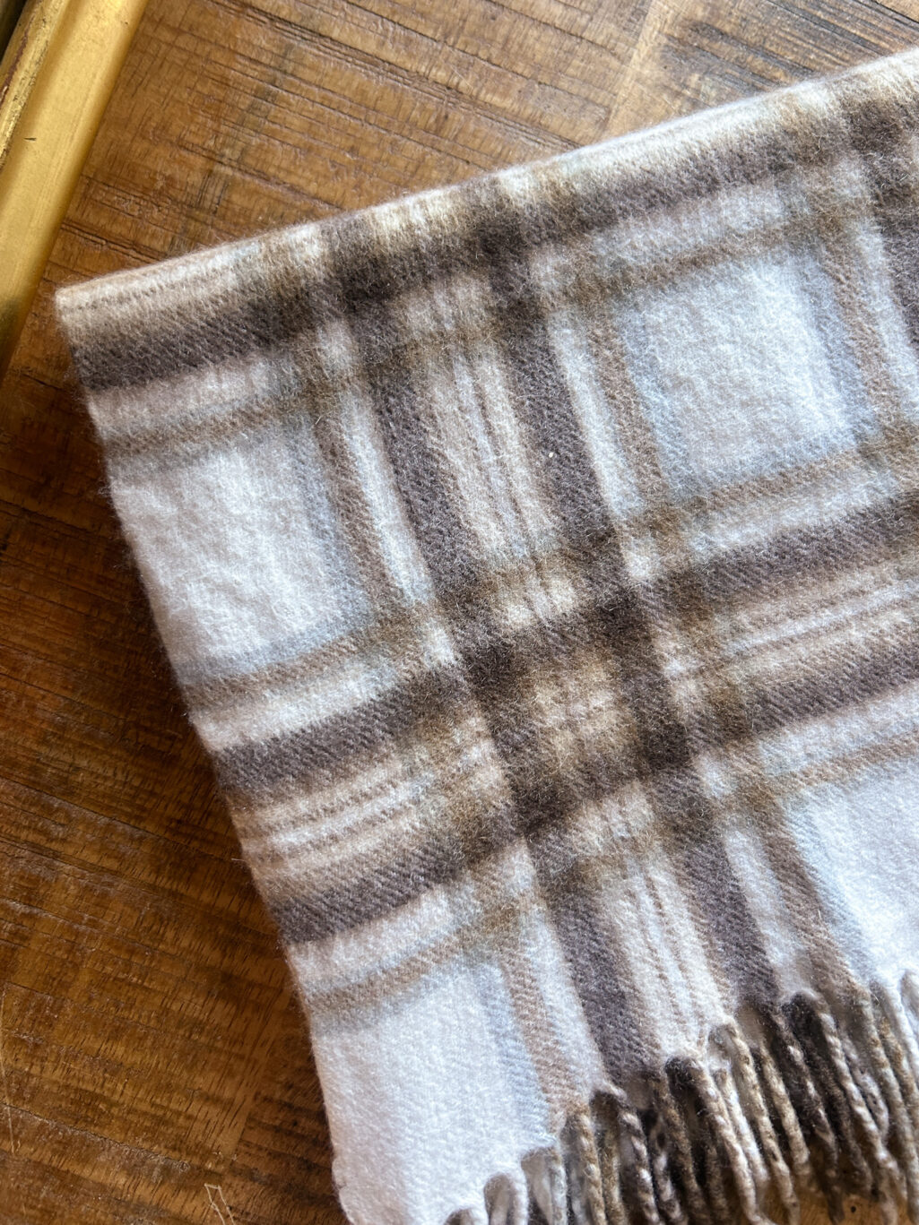 Preloved Schal mit Karomuster von Lochmere. Gefaltet auf Holztisch.