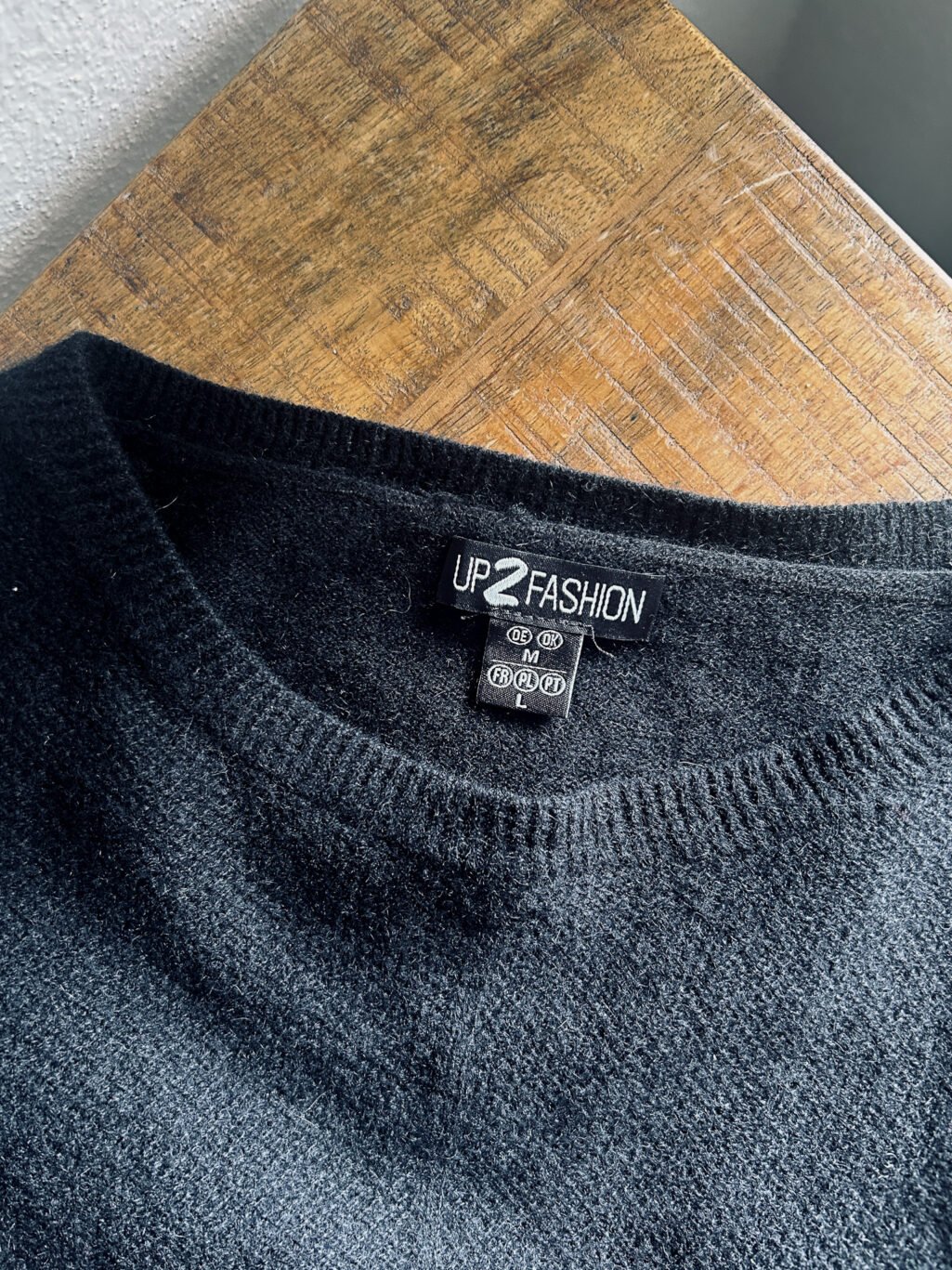 Up2Fashion Pullover aus 100% Kaschmir in Schwarz. Preloved, gefaltet auf Holztisch.