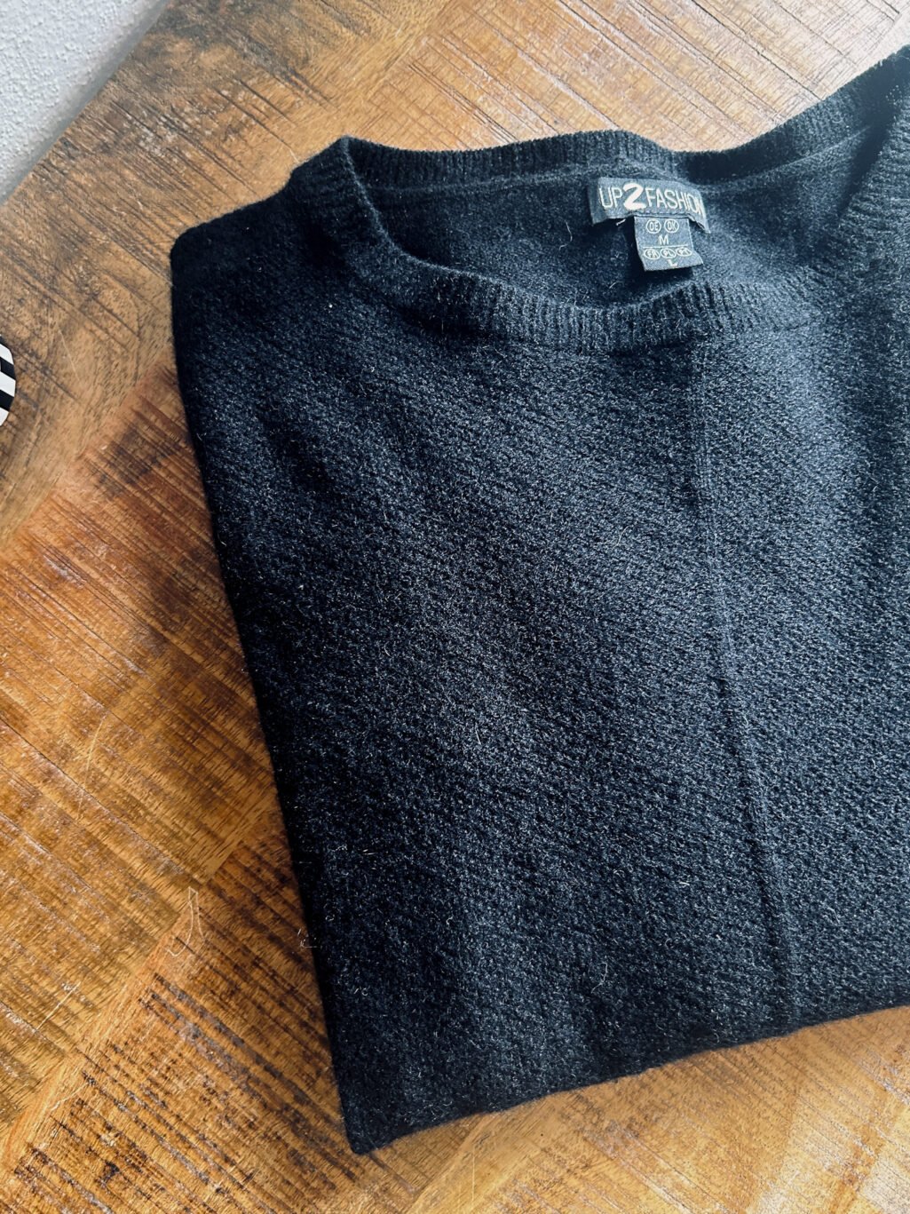 Up2Fashion Pullover aus 100% Kaschmir in Schwarz. Preloved, gefaltet auf Holztisch.