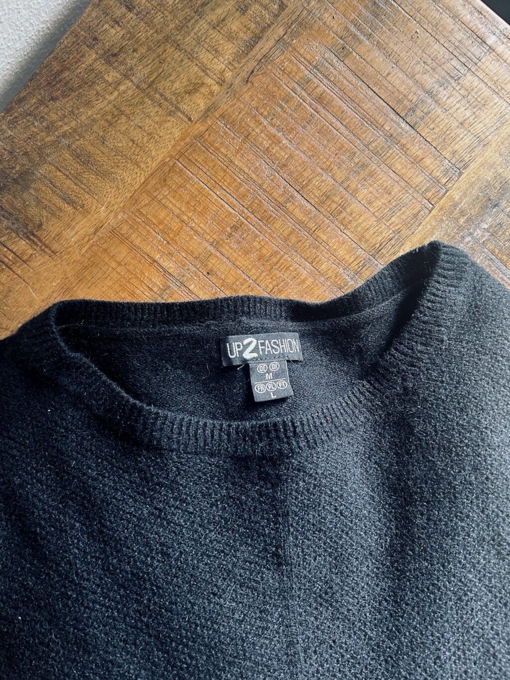 Up2Fashion Pullover aus 100% Kaschmir in Schwarz. Preloved, gefaltet auf Holztisch.