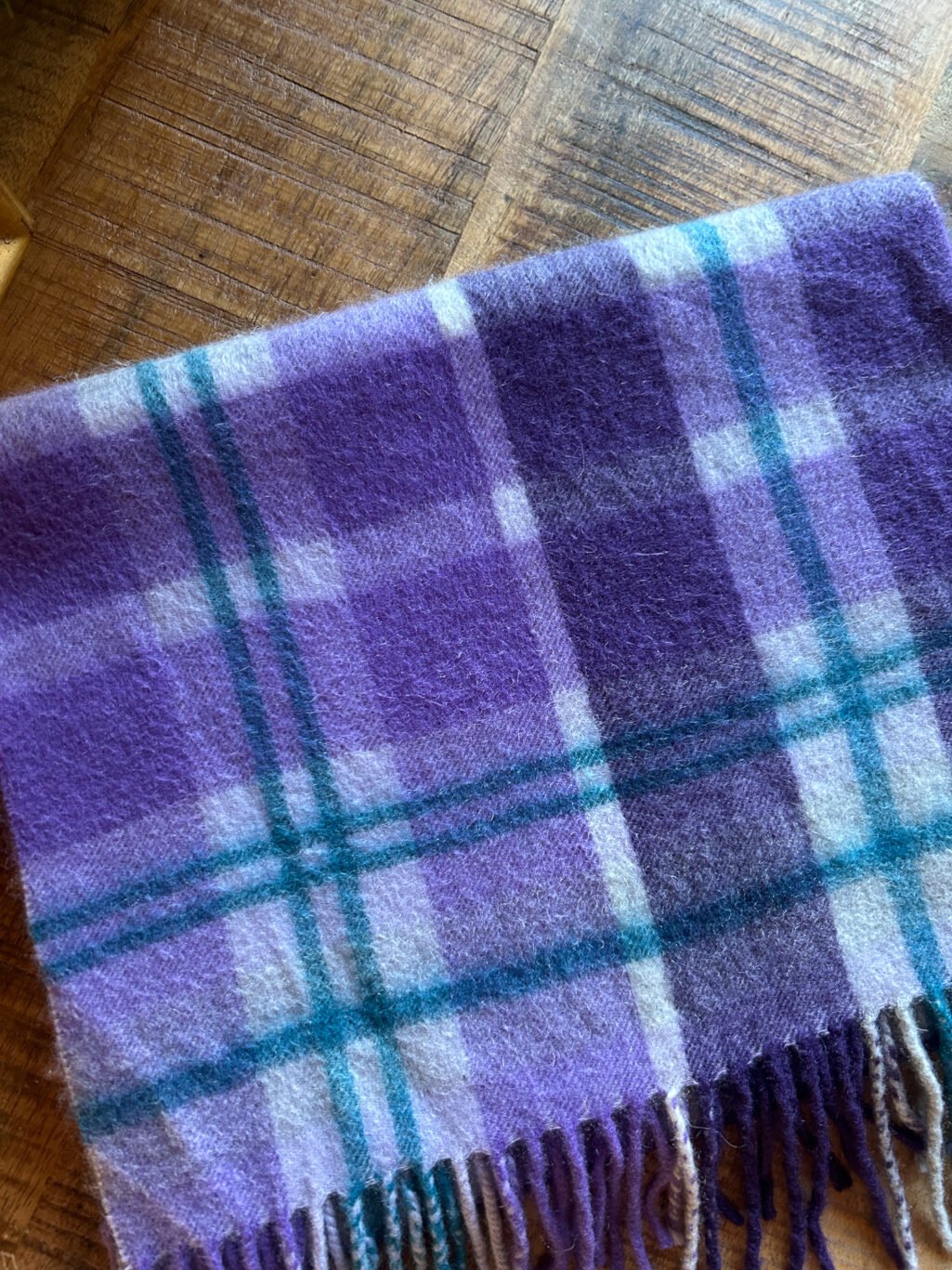 Preloved Nordstrom Schal, kariert aus 100% Cashmere in Violett. Gefaltet auf Holztisch.
