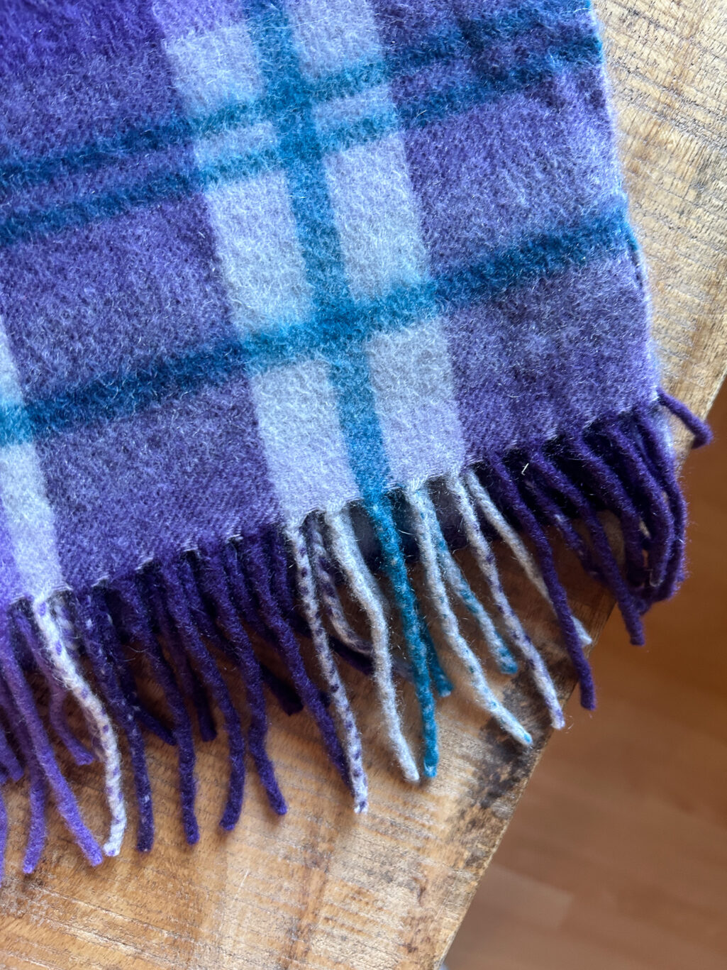 Preloved Nordstrom Schal, kariert aus 100% Cashmere in Violett. Gefaltet auf Holztisch.